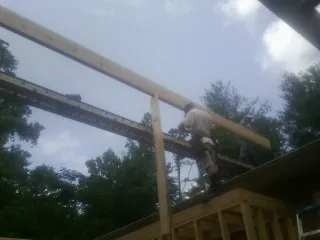 Carpenter setting a ridge beam over a new addition frame — Ice Dam Removal by Roofing Brothers in Peoria Heights