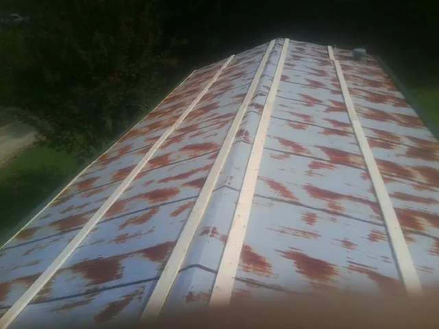 Rusted metal roof panels with new wood purlins before replacement — Storm Damage Roof Repair in Peoria Heights by Roofing Brothers