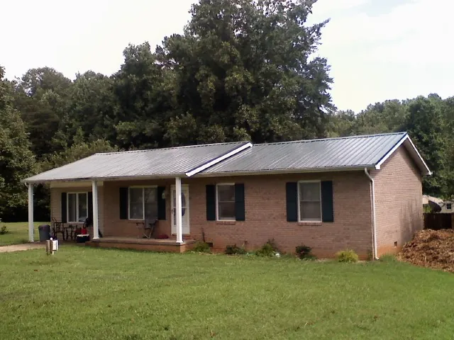 Gray metal roof on a brick ranch house with a side carport in Peoria Heights
