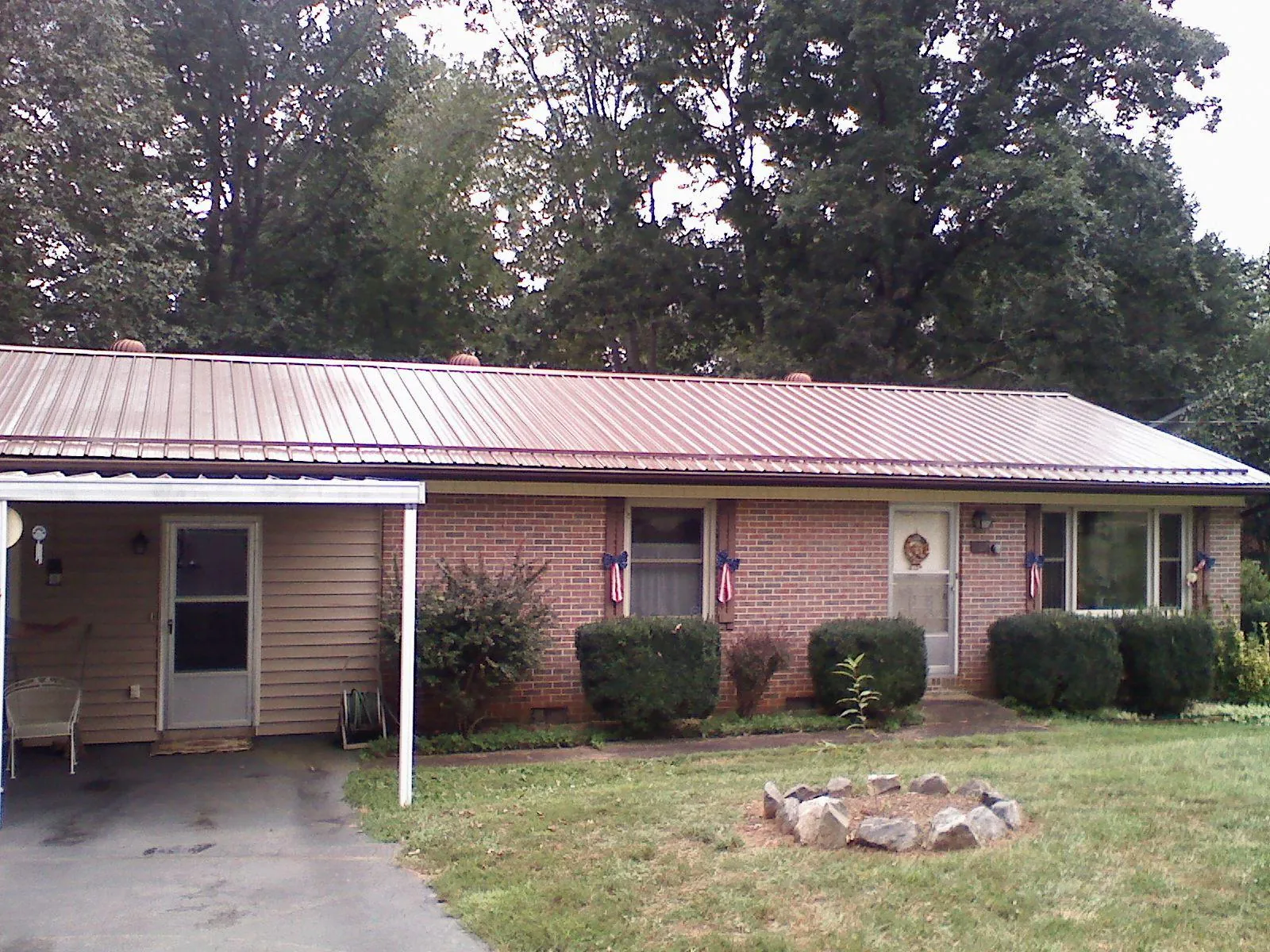 Bronze metal roof and carport on a brick ranch home — Roof Repair work by our crew in Peoria Heights